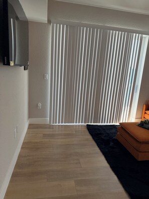 A room with a wooden floor, a black furry rug, and a brown sofa. - 2-bedroom apartment in lovely Daytona Beach with AC  for Corporate Housing only. (Daytona Beach)