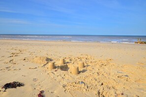 A sandy beach with footprints and three sand sculptures. - 2 Bed in Mundesley (oc-1991) (Mundesley)