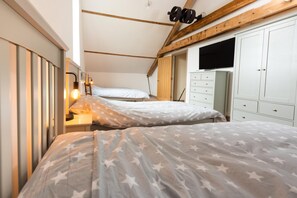 A bedroom with two beds, a wardrobe, and a television. - 4 Bed in White Horse Common (oc-1945) (Witton)
