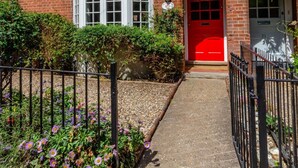 A two-story house with a red door, white windows, and a brick exterior. - 4 Bed in Mundesley (oc-1997) (Mundesley)