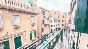 Una calle estrecha con edificios que tienen balcones y contraventanas.