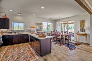 A spacious kitchen with a large island, dark cabinetry, and a patterned rug. - Casa Bella - Hot tub, well equipped and mountain views (Santa Fe)