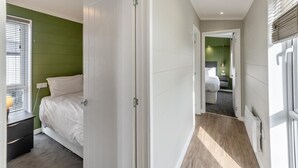 Quarto com cama, mesa de cabeceira e abajur.