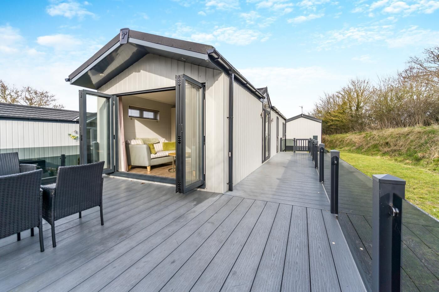 A modern building with a deck, a sofa, and a table.
