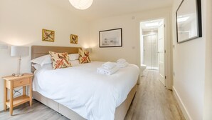 A hotel room with a bed, bedside table, lamp, and artwork on the wall. - 3 Bed in Bamburgh (oc-w31886) (Bamburgh)