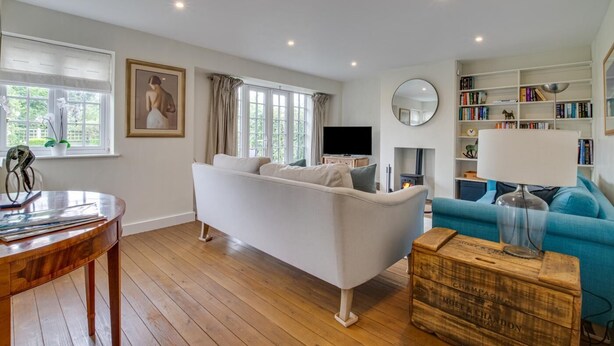 A modern living room with a white sofa, a blue sofa, a wooden coffee table, a bookshelf, and a fireplace. - 4 Bed in Walberswick (oc-4ms) (Walberswick)