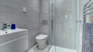 A modern bathroom with a glass-enclosed shower, a white sink, and a toilet. - 4 Bed in Beadnell (oc-gd1280) (Beadnell)