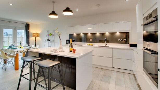 A modern kitchen with a central island, bar stools, pendant lighting, and a view of the outdoors. - 4 Bed in Beadnell (oc-gd1280) (Beadnell)