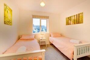 A bedroom with two single beds, a window with a view, and artwork on the walls. - 4 Bed in Beadnell (oc-gd1280) (Beadnell)