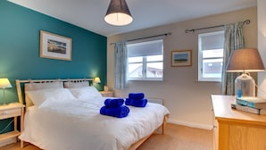 A bedroom with a bed, two bedside tables, a nightstand, a lamp, and a dresser. - 4 Bed in Beadnell (oc-gd1697) (Beadnell)