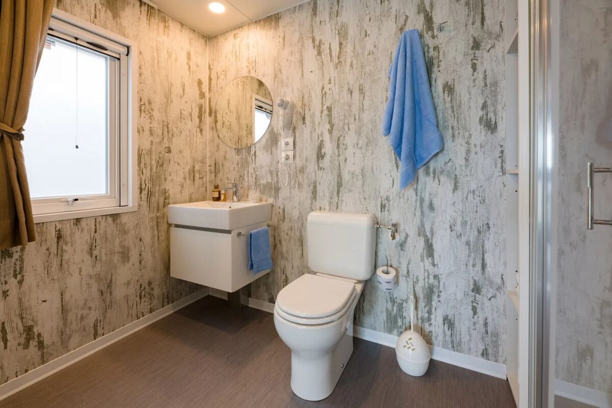 Un bagno con il water, un lavandino e uno specchio.
