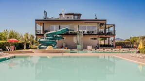 Um edifício moderno com piscina, toboágua e área de estar externa.