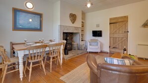 A cozy living room with a fireplace, wooden furniture, and a television. - 2 Bed in Bamburgh (oc-gd1345) (Bamburgh)