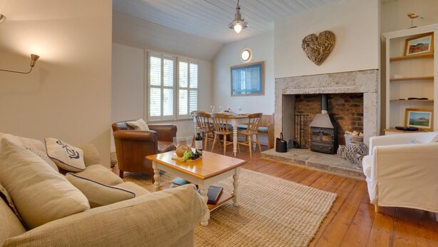 A cozy living room with a fireplace, a dining area, and a seating area with a sofa and chairs. - 2 Bed in Bamburgh (oc-gd1345) (Bamburgh)