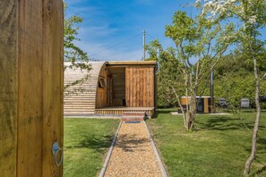 A wooden cabin with a porch, surrounded by a grassy yard and trees. - 1 Bed in Sandown (oc-h31917) (Newchurch)