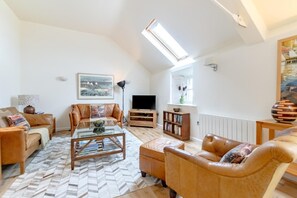 A living room with a sofa, armchair, coffee table, and bookshelf. - 2 Bed in Waren Mill (oc-gd1324) (Waren Mill)