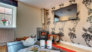 Ein gemütliches Wohnzimmer mit Kamin, Flachbildfernseher und Bücherregal.
