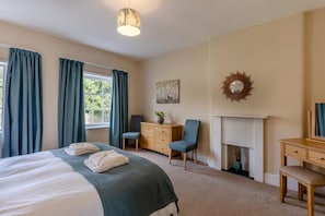A hotel room with a bed, two chairs, a dresser, a mirror, and a fireplace. - 2 Bed in Ludlow (oc-d31885) (Ludlow)