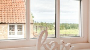 A window with a view of a house and a field, a white wall, and a 'love' decoration. - 3 Bed in Belford (oc-gd0144) (Adderstone with Lucker)