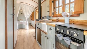Une cuisine chaleureuse avec un fourneau, un évier et des armoires en bois.