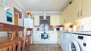 A compact kitchen with a built-in oven, microwave, and washing machine. - 2 Bed in Saltburn-by-the-Sea (oc-cl004) (Saltburn-by-the-Sea)
