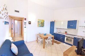 Um espaço compacto com área de refeições, cozinha compacta e sofá.