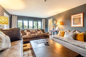 Ein modernes Wohnzimmer mit zwei Sofas, einem Couchtisch und einer Lampe.