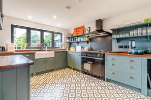 Una cocina con piso estampado, estufa y ventana con vista a follaje.