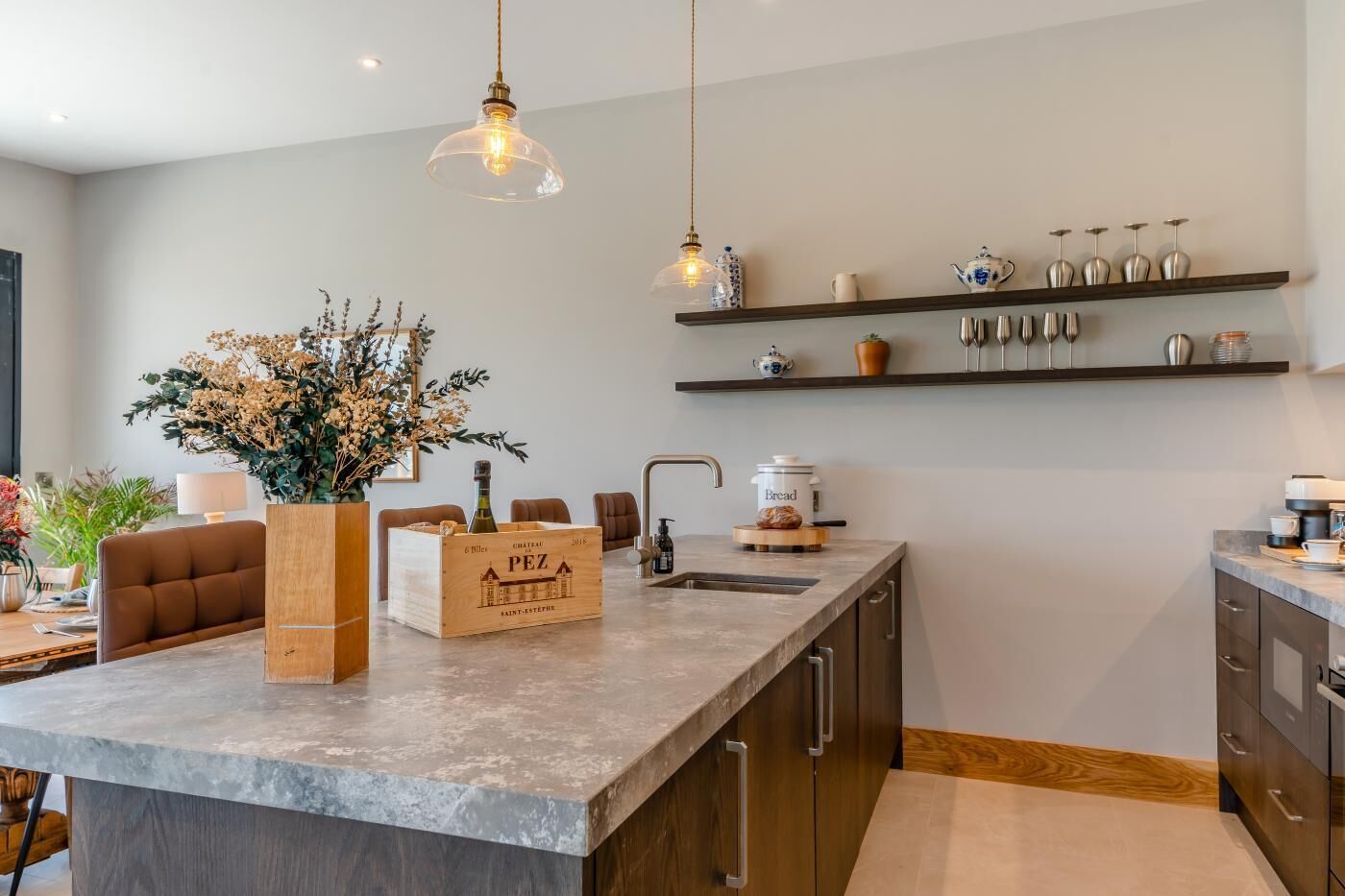 Een moderne keuken met een centraal eiland, houten kastjes en een inbouwoven.