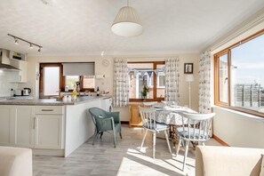 Une cuisine moderne avec un coin repas, de grandes fenêtres et une vue sur la ville.
