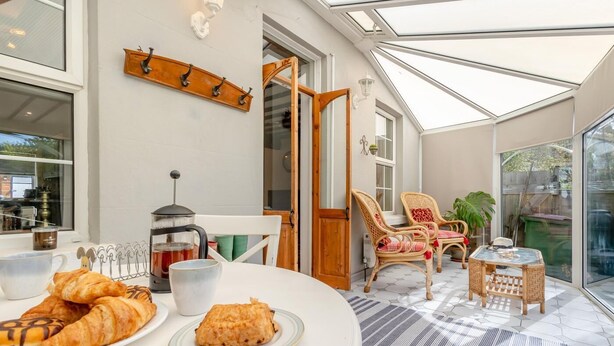 A cozy breakfast setting with croissants, a coffee pot, and wicker chairs. - 3 Bed in Hythe (oc-o31997) (Hythe)