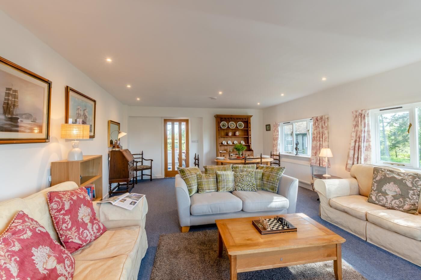 A cozy living room with a sofa, a coffee table, and a dining area with a table and chairs.