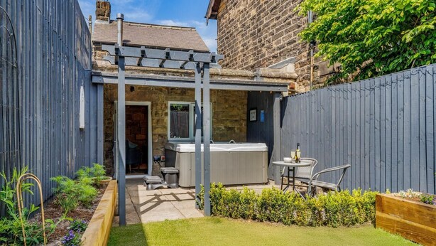 A backyard with a hot tub, a pergola, and a small patio area. - 1 Bed in Darley Dale (oc-w32014) (Northwood and Tinkersley)