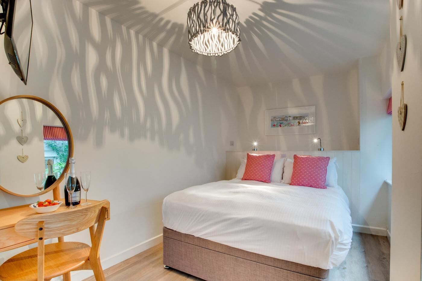 Un dormitorio con cama, mesita de noche y espejo.