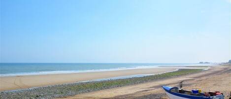 A beach with a small boat on a trailer.