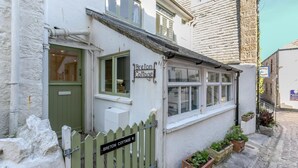 A white building with a sign reading "Breton Cottage." - 2 Bed in St. Ives (oc-b31979) (St Ives)