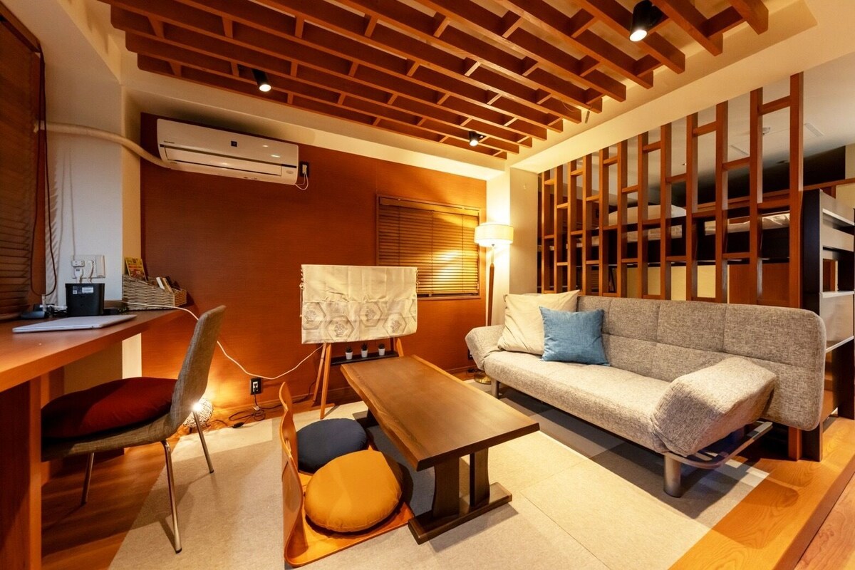 A modern living room with a wooden ceiling, a sofa, a table, and a chair.