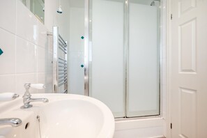 A bathroom with a glass shower enclosure, a white sink with a chrome faucet, and a towel rack. - 2 Bed in St. Merryn (oc-p00801) (Saint Merryn)