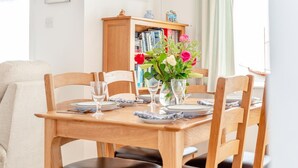 Ett matbord dukat med tallrikar, glas och en vas med blommor.