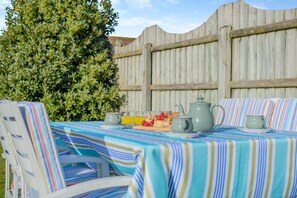 A table set outdoors with striped tablecloths, a teapot, cups, and a fruit platter. - 2 Bed in St. Merryn (oc-p00801) (Saint Merryn)