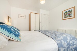 A bedroom with a bed, a wardrobe, a door, and a framed picture on the wall. - 2 Bed in St. Merryn (oc-p00801) (Saint Merryn)