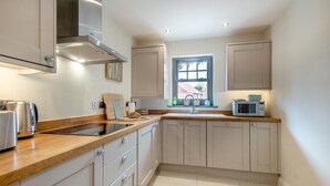 A modern kitchen with wooden countertops, stainless steel appliances, and light-colored cabinetry. - 2 Bed in Mundesley (oc-r31875) (Mundesley)