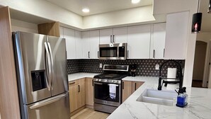 A modern kitchen with stainless steel appliances, a marble countertop, and a patterned backsplash. - Walk to Sabino Canyon Trails, 4Bd Home with Hot Tub (Tucson)