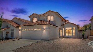 A two-story house with a garage, a driveway, and a gravel front yard. - Walk to Sabino Canyon Trails, 4Bd Home with Hot Tub (Tucson)