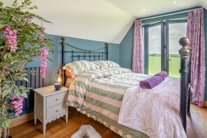 Una camera da letto con un letto, un comodino, una lampada e vista sull'esterno.