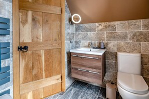 Un bagno con porta in legno, un lavandino con specchio e un water.