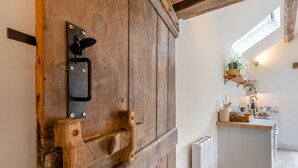 A rustic wooden door with a black handle and a metal latch.