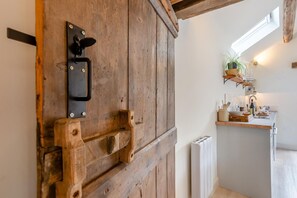 A rustic wooden door with a black handle and a metal latch.