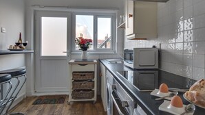 Een moderne keuken met een raam, een magnetron, een broodrooster en een spoelbak.