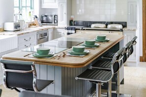 Eine moderne Küche mit Kochinsel, Barhocker und Mikrowelle.